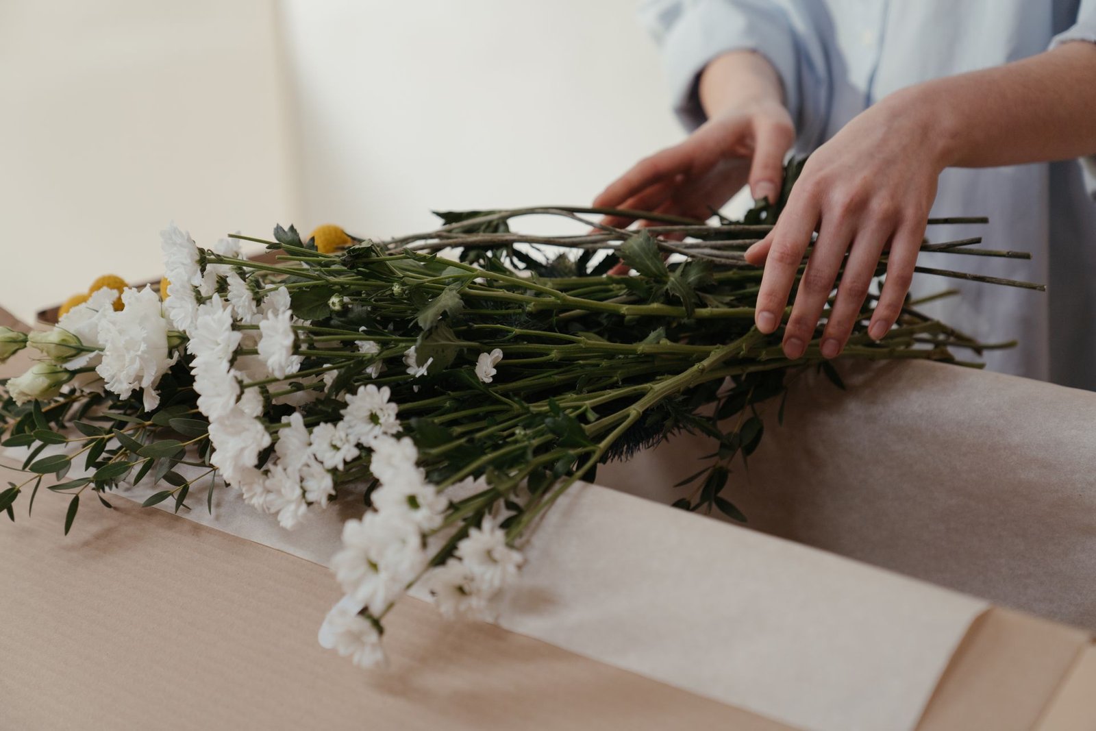Florist hands white flowers kraft paper - The Petal Studio Chandigarh
